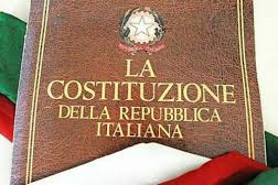 testo della costituzione italiana; sullo sfondo la bandiera italiana