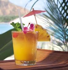 immagine di un aperitivo: bicchiere con bibita decorato con frutta e ombrellini colorati