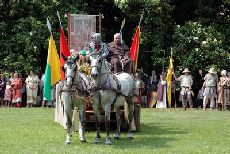 immagine di carro trainato da cavalli con persone in costume medievale