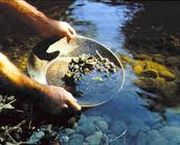 strumento per la ricerca dell'oro, con all'interno delle pietre, semi immerso nell'acqua 